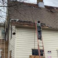 man on ladder working on the roof